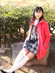 Japanese tramp poses in her school uniform as she waits