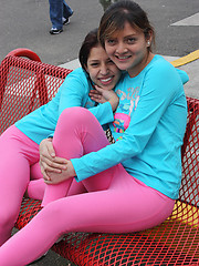 Two latina girls in tight pink leggings have fun in the park