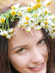 Adorable busty teen girl posing in only a wreath of daisies on her head in a sand quarry.