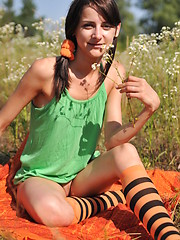 Marvelous teen girl in striped socks undressing and showing slender body on the nature.