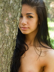 Fresh and exotic beautiful Malina relaxes amongst the lush grass and trees.