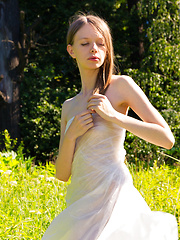 Gorgeous slim girl posing absolutely naked outdoor in the field on the plastic sheeting.