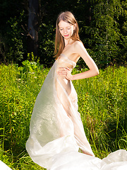 Gorgeous slim girl posing absolutely naked outdoor in the field on the plastic sheeting.