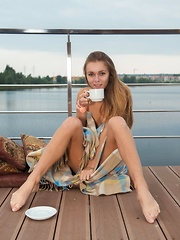 Katie A sips on her coffee as she enjoys the cool, balmy air on her naked body.